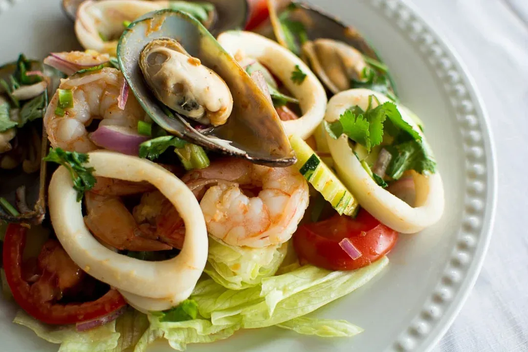 Seafood salad with shrimp, squid rings and mussels on lettuce